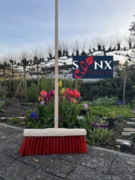 Stadsbezem met rode borstelharen in tuinomgeving