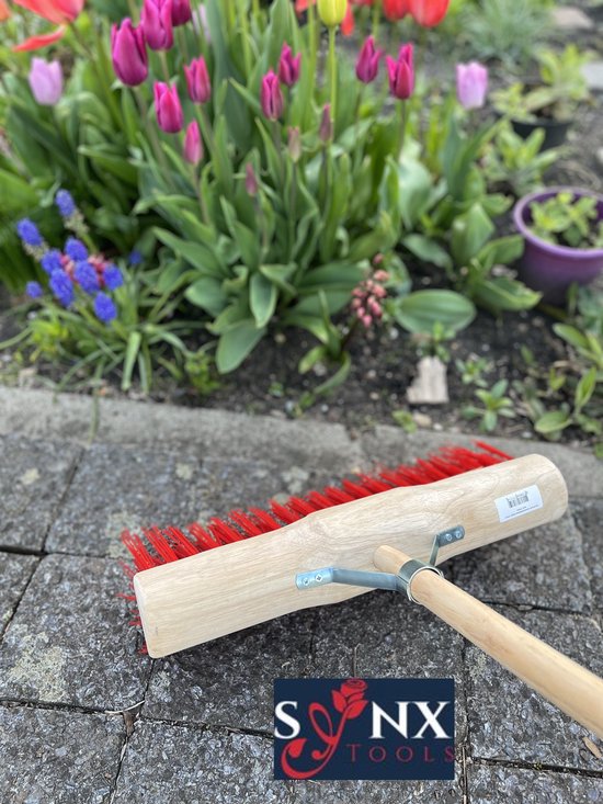 Buitenbezem op stenen pad met bloemen op achtergrond