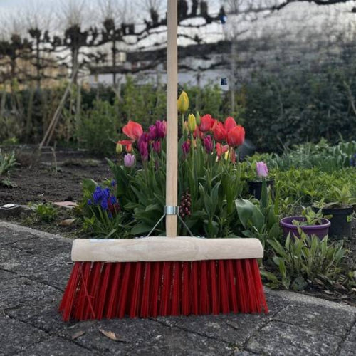 Gemeentebezem 45 cm met rode haren in tuin met tulpen