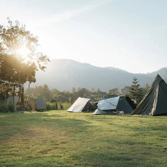 Kampeerplaats met tent, parasol en campinguitrusting – Synx Store