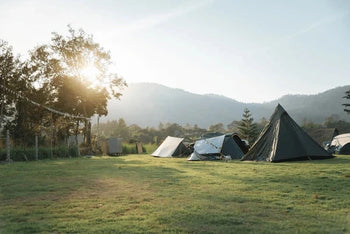 Kampeerplaats met tent, parasol en campinguitrusting – Synx Store