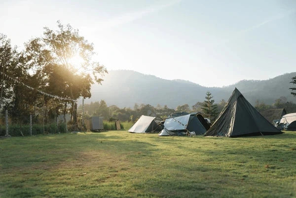 Kampeerplaats met tent, parasol en campinguitrusting – Synx Store